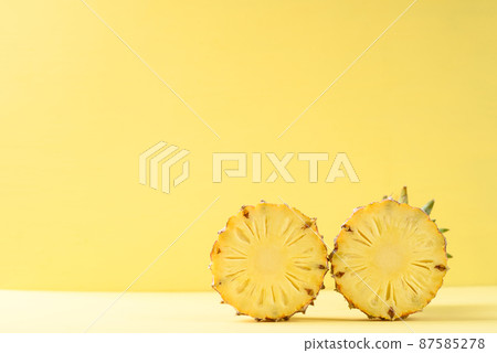 Half pineapple fruit on yellow background, Tropical fruit 87585278