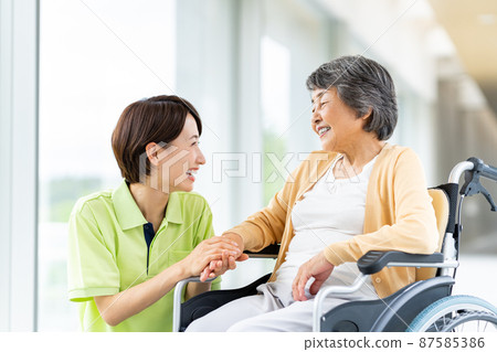 坐輪椅的高級婦女和中級護理人員 坐輪椅的高級婦女和中級護理人員 87585386