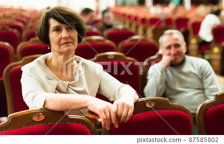 mature man and woman in theater watching a performance 87585802