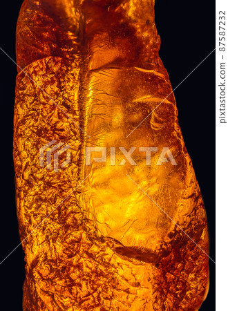 Natural amber texture. Multicolored background for advertising and banners. Vintage fossilized resin as a background. Red amber amber background. Close-up amber Natural amber texture. Multicolored background for advertising and banners. Vintage fossilized resin as a background. Red amber amber background. Close-up amber 87587232