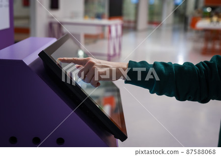 Close-up of a woman using a touch screen information booth. Close-up of a woman using a touch screen information booth. 87588068