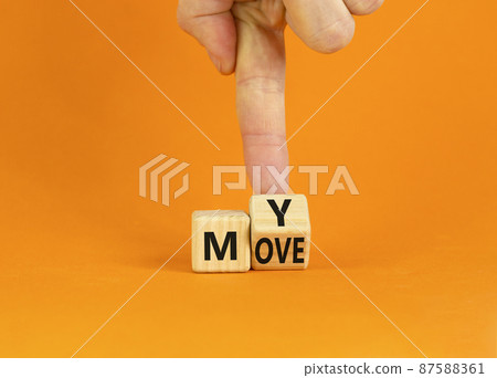 Make my move symbol. Businessman turns the wooden cube with words 'My move'. Beautiful orange background. Make my move and business concept. Copy space. 87588361