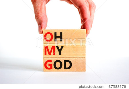 OMG oh my god symbol. Concept words OMG oh my god on wooden blocks on a beautiful white table, white background. Businessman hand. Business and OMG oh my god concept. Copy space. 87588376