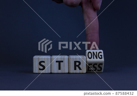Strong stress symbol. Doctor turns a wooden cube with concept words strong stress. Beautiful grey table, grey background, copy space. Business, medical, psychology and strong stress concept. 87588432