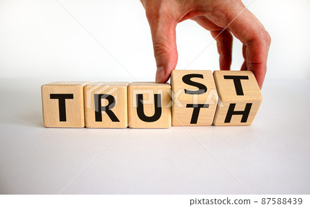 Truth or trust symbol. Male hand turns wooden cubes and changes the word 'Truth' to 'Trust'. Beautiful white background. Business and truth or trust concept, copy space. 87588439