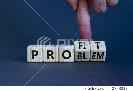 Solving a problem and making profit symbol. Businessman turns wooden cubes, changes the word 'problem' to 'profit'. Beautiful grey background. Business, problem to profit concept. Copy space. Solving a problem and making profit symbol. Businessman turns wooden cubes, changes the word 'problem' to 'profit'. Beautiful grey background. Business, problem to profit concept. Copy space. 87588453