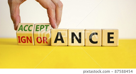 Acceptance or ignorance symbol. Businessman turns cubes, changes the word 'ignorance' to 'acceptance'. Beautiful yellow table, white background. Business, acceptance or ignorance concept. Copy space. Acceptance or ignorance symbol. Businessman turns cubes, changes the word 'ignorance' to 'acceptance'. Beautiful yellow table, white background. Business, acceptance or ignorance concept. Copy space. 87588454