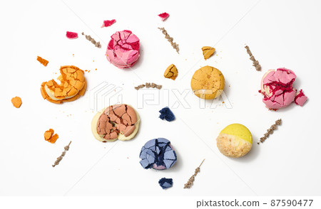 broken round macarons with crumbs on a white background, delicious dessert, top view 87590477