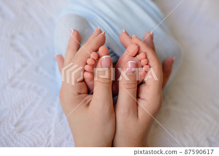 Small beautiful legs of a newborn baby in the first days of life Small beautiful legs of a newborn baby in the first days of life 87590617