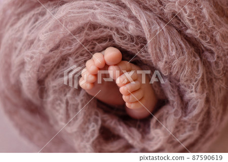 Small beautiful legs of a newborn baby in the first days of life Small beautiful legs of a newborn baby in the first days of life 87590619