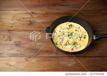 Fried eggs sprinkled with parsley in skillet on dark wooden table, Homemade breakfast. Fried eggs sprinkled with parsley in skillet on dark wooden table, Homemade breakfast. 87591008