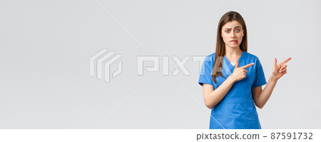 Healthcare workers, prevent virus, insurance and medicine concept. Nervous female intern worried standing in hospital. Doctor or nurse nervously biting lip and pointing fingers right 87591732