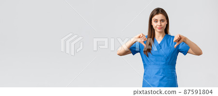 Healthcare workers, prevent virus, insurance and medicine concept. Skeptical and upset nurse or doctor in blue scrubs, smirk disappointed, showing thumbs-down dislike something 87591804