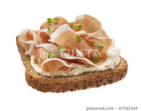 Toasted bread with prosciutto isolated on white background 87592384