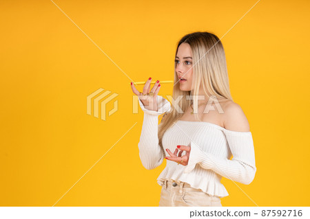 young girl sending audio message with smartphone to friend young girl sending audio message with smartphone to friend 87592716