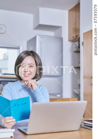 年輕女子拿著養老金書看著鏡頭 年輕女子拿著養老金書看著鏡頭 87595079