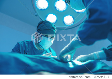 In the operating room of a hospital, a group of surgeons are performing surgery. In the operating room of the hospital's surgical venous vascular surgery clinic, an Asian doctor and an assistant. In the operating room of a hospital, a group of surgeons are performing surgery. In the operating room of the hospital's surgical venous vascular surgery clinic, an Asian doctor and an assistant. 87595197