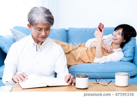 中間父親和小女兒的父母和孩子在客廳裡放鬆 中間父親和小女兒的父母和孩子在客廳裡放鬆 87595338