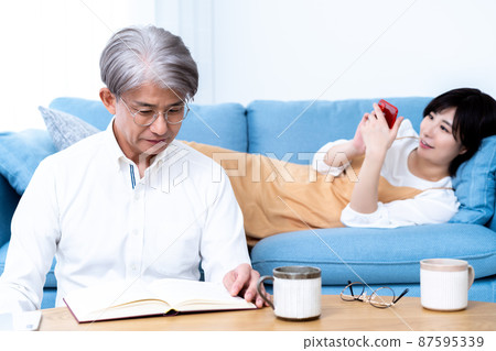 中間父親和小女兒的父母和孩子在客廳裡放鬆 中間父親和小女兒的父母和孩子在客廳裡放鬆 87595339