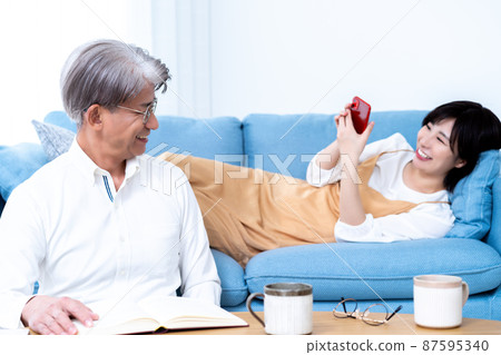 中間父親和小女兒的父母和孩子在客廳裡放鬆 中間父親和小女兒的父母和孩子在客廳裡放鬆 87595340