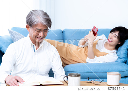 中間父親和小女兒的父母和孩子在客廳裡放鬆 中間父親和小女兒的父母和孩子在客廳裡放鬆 87595341