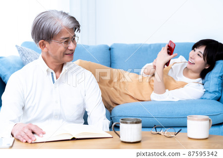 中間父親和小女兒的父母和孩子在客廳裡放鬆 中間父親和小女兒的父母和孩子在客廳裡放鬆 87595342