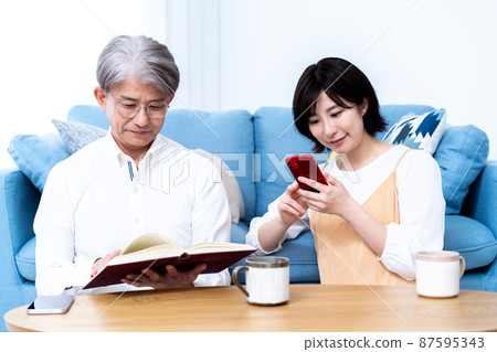 中間父親和小女兒的父母和孩子在客廳裡放鬆 中間父親和小女兒的父母和孩子在客廳裡放鬆 87595343