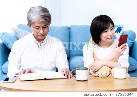 中間父親和小女兒的父母和孩子在客廳裡放鬆 中間父親和小女兒的父母和孩子在客廳裡放鬆 87595344