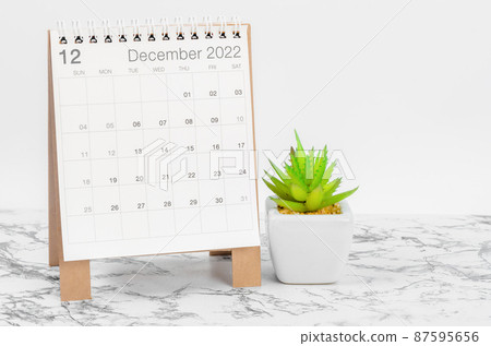 December 2022 desk calendar with plant on marble table. December 2022 desk calendar with plant on marble table. 87595656