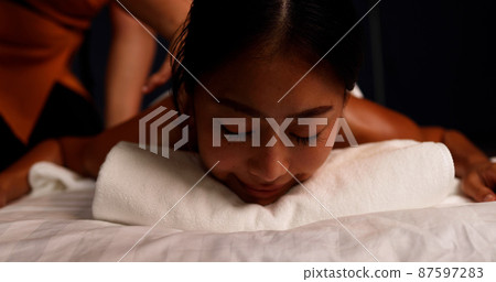 Young Asian woman receiving a shoulder massage at spa salon by professional masseuse, Spa treatment and thai massage concept Young Asian woman receiving a shoulder massage at spa salon by professional masseuse, Spa treatment and thai massage concept 87597283