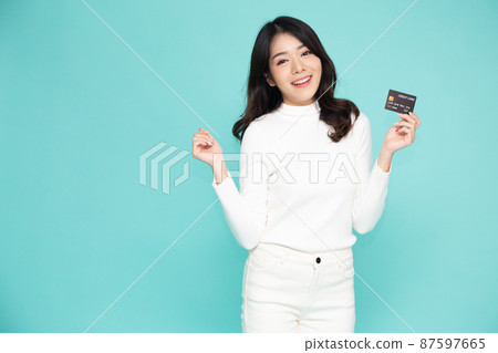Young beautiful Asian woman smiling, showing, presenting credit card for making payment or paying online business, Pay a merchant or as a cash advance for goods, Cardholder or A person who owns a card Young beautiful Asian woman smiling, showing, presenting credit card for making payment or paying online business, Pay a merchant or as a cash advance for goods, Cardholder or A person who owns a card 87597665