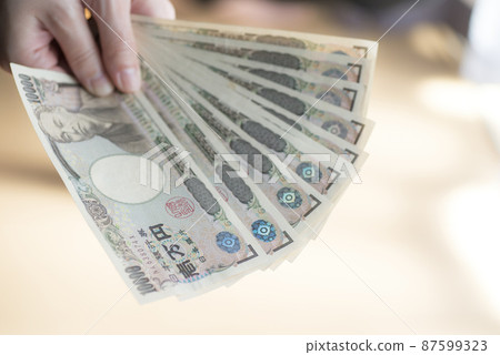 Hand holding 100,000 yen 87599323