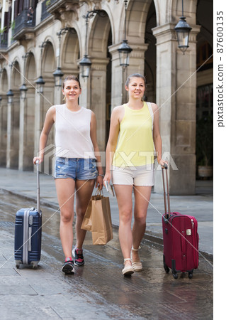 female tourists exploring old european city with baggage female tourists exploring old european city with baggage 87600135