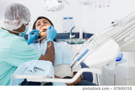 Male dentist treating female patient in dental clinic Male dentist treating female patient in dental clinic 87600358