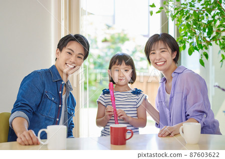 一個女孩和一對年輕夫婦練習錄音機 87603622