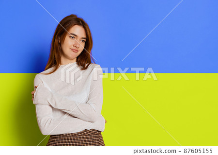 Portrait of young girl posing isolated over blue and yellow ukrainian flag background. 87605155