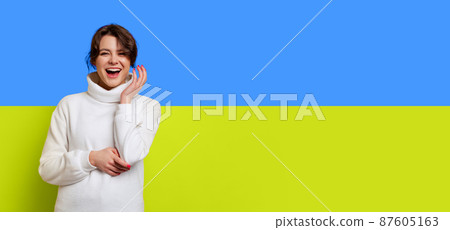 Portrait of young beautiful woman cheerfully smiling isolated over blue and yellow ukrainian flag background Portrait of young beautiful woman cheerfully smiling isolated over blue and yellow ukrainian flag background 87605163
