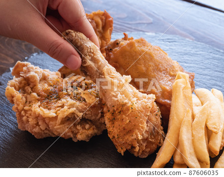 炸雞和炸薯條。脆皮炸雞和土豆菜餚。 87606035