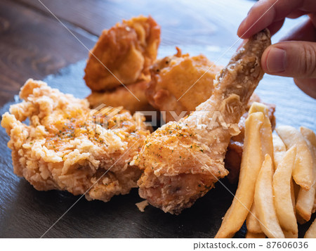 炸雞和炸薯條。脆皮炸雞和土豆菜餚。 87606036