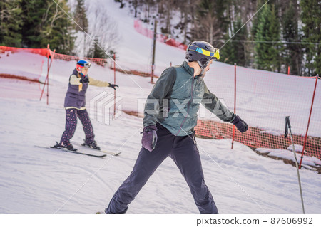 Woman learning to ski with instructor. Winter sport. Ski lesson in alpine school Woman learning to ski with instructor. Winter sport. Ski lesson in alpine school 87606992