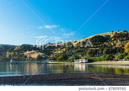 A town located on the Banks Peninsula on the South Island of New Zealand, the streets of Akaroa and the scenery of Akaroa Bay A town located on the Banks Peninsula on the South Island of New Zealand, the streets of Akaroa and the scenery of Akaroa Bay 87609560
