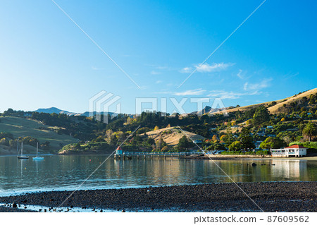A town located on the Banks Peninsula on the South Island of New Zealand, the streets of Akaroa and the scenery of Akaroa Bay A town located on the Banks Peninsula on the South Island of New Zealand, the streets of Akaroa and the scenery of Akaroa Bay 87609562