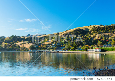 A town located on the Banks Peninsula on the South Island of New Zealand, the streets of Akaroa and the scenery of Akaroa Bay A town located on the Banks Peninsula on the South Island of New Zealand, the streets of Akaroa and the scenery of Akaroa Bay 87609564