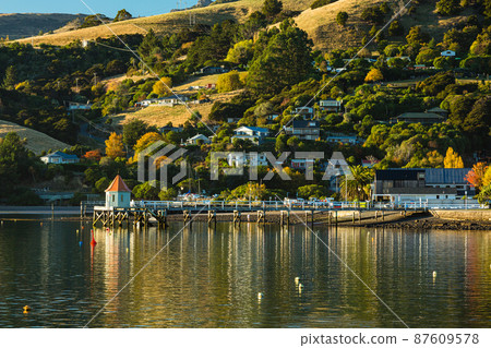 A town located on the Banks Peninsula on the South Island of New Zealand, the streets of Akaroa and the scenery of Akaroa Bay A town located on the Banks Peninsula on the South Island of New Zealand, the streets of Akaroa and the scenery of Akaroa Bay 87609578
