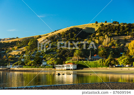 A town located on the Banks Peninsula on the South Island of New Zealand, the streets of Akaroa and the scenery of Akaroa Bay A town located on the Banks Peninsula on the South Island of New Zealand, the streets of Akaroa and the scenery of Akaroa Bay 87609594