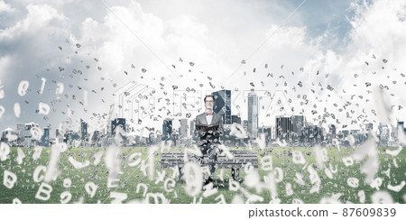 Young businessman or student studying the science and symbols fly around Young businessman or student studying the science and symbols fly around 87609839
