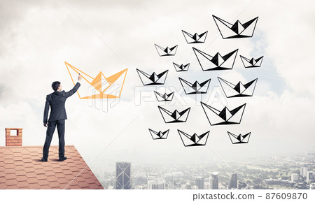 Businessman standing with back on house brick roof and drawing. Businessman standing with back on house brick roof and drawing. 87609870
