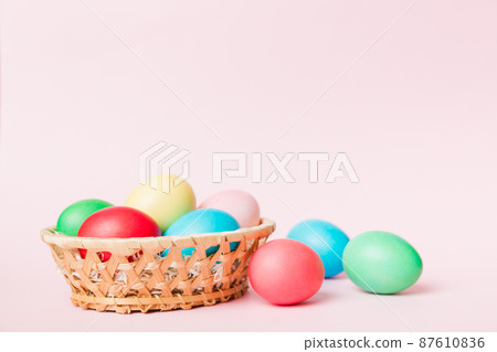 Multi colors Easter eggs in the woven basket on colored background . Pastel color Easter eggs. holiday concept with copy space Multi colors Easter eggs in the woven basket on colored background . Pastel color Easter eggs. holiday concept with copy space 87610836