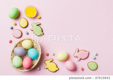 Colorful easter cookies in basket with Multi colors Easter eggs on colored background . Pastel color Easter eggs. holiday concept with copy space Colorful easter cookies in basket with Multi colors Easter eggs on colored background . Pastel color Easter eggs. holiday concept with copy space 87610842