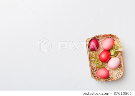 Multi colors Easter eggs in the woven basket on colored background . Pastel color Easter eggs. holiday concept with copy space Multi colors Easter eggs in the woven basket on colored background . Pastel color Easter eggs. holiday concept with copy space 87610865